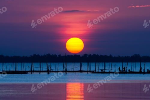 Preview: Big Sun At The Lake With Silhouette Of Fisherman.
