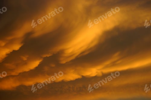 Vorschau: Orangefarbene Wolke am Sonnenuntergangshimmel.
