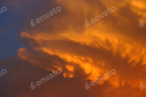 Vorschau: Orangefarbene Wolke am Sonnenuntergangshimmel.
