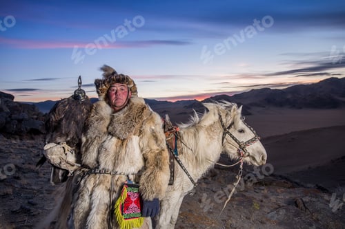 Preview: Mongolian Eagle Hunter In Traditional Clothing, Holding A Golden Eagle On His Arm And Rider Horse