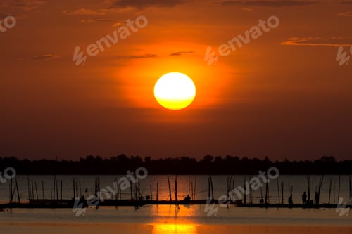 Preview: Big Sun At The Lake With Silhouette Of Fisherman.