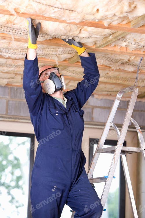 Preview: A Portrait Shot Of A Man Wearing Protective Mask Looking Up And Installing Ceiling Insulation.