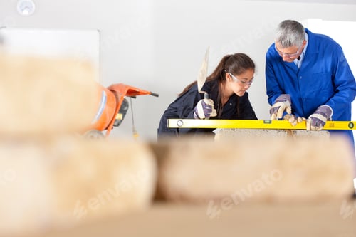 Preview: A Shot Of A Teacher Teaching A Young Girl How To Use Level Tool With Bricks In Foreground.