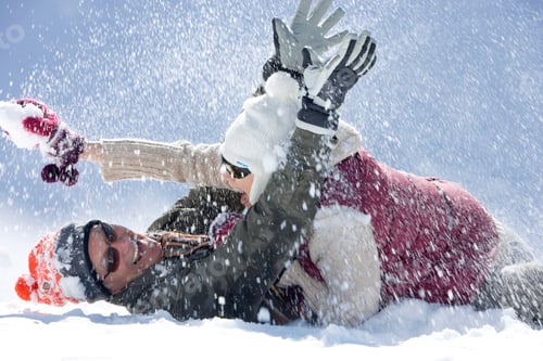 Preview: A Fun Senior Couple Lying On The Ground While Playfully Throwing Snow At Each Other At The Top Of A