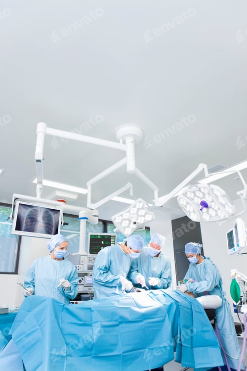 Preview: A Vertical View Of A Medical Team Performing Surgical Operations While Standing Around Some Latest