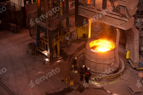 Preview: A High Angle Wide Shot Of Engineers Standing Near Hot Forged Steel In A Foundry.