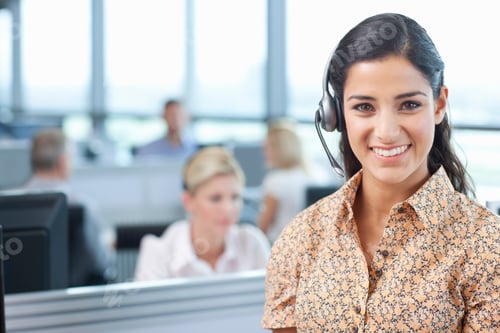 Preview: A Portrait Of A Smiling Businesswoman Wearing A Headset In The Office With People Working In The