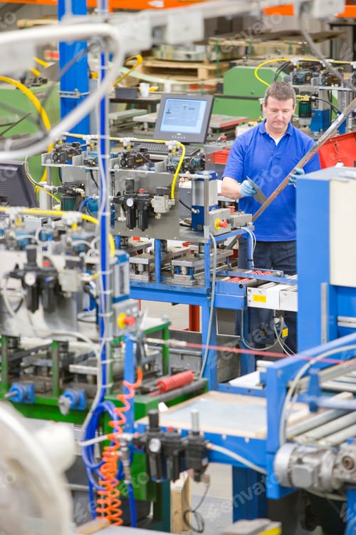 Preview: A Portrait Shot Of A Worker Inspecting Aluminum Light Fitting Standing Behind Machinery In A