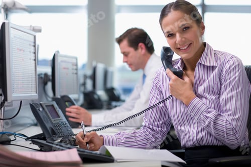 Preview: A Medium Shot Of A Businesswoman Smiling At Camera While Talking On A Telephone In Office.