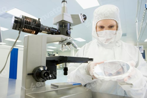 Preview: A Horizontal View Of A Scientist In Clean Suit Closely Examining The Silicon Wafer While Standing