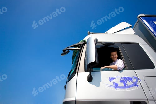 Preview: A Low Angle Shot Of A Happy Truck Driver Looking At The Camera Through The Open Window Of A
