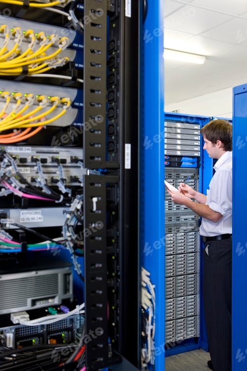 Preview: Vertical Wide Shot Of An It Technician Holding Pen And Paper Examining Lan Network In Selective