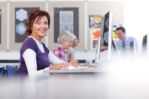 Preview: A Medium Shot Of A Senior Woman Smiling At Camera While Using A Computer In A Lab.