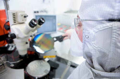 Preview: Close Up Of A Scientist In Clean Suit With Selective Focus Examining The Silicon Wafer Under A
