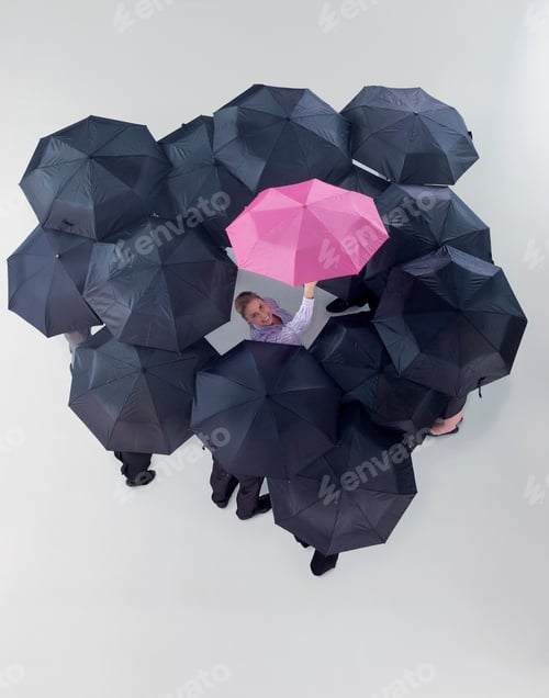 Preview: Overhead Shot Of A Group Of Businesspeople Holding Black Umbrellas With A Businesswoman In A Pink