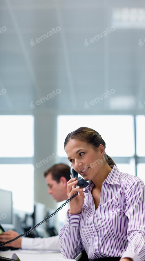 Preview: A Vertical Shot Of A Businesswoman Talking On A Telephone In Office.