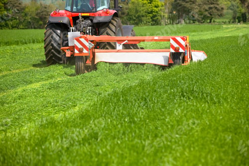 Preview: A Medium Closeup Of A Flail Mower Attached To A Tractor Running Through The Field While Cutting The