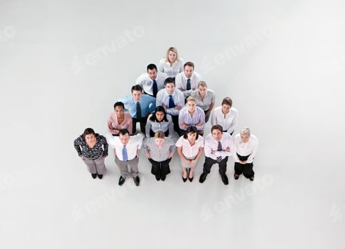 Preview: Overhead Shot Of A Group Of Businesspeople Standing In A Pyramid Formation Looking At The Camera.