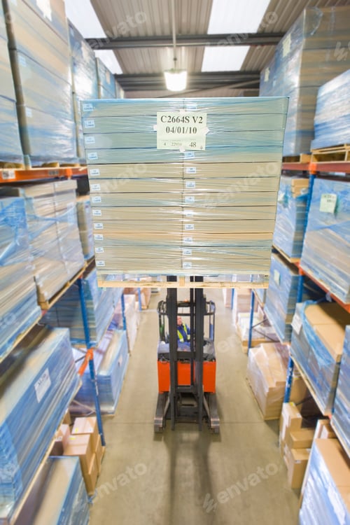 Preview: A Portrait Shot Of A Boxes Lifted Using A Forklift By A Warehouse Worker.