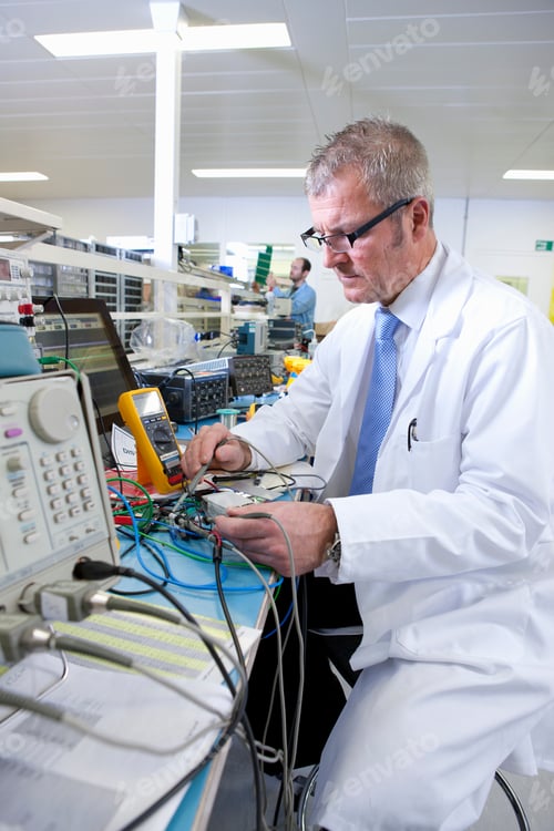 Preview: A Vertical View Of An Engineer Sitting At The Test Bench While Checking A Circuit Board With Test