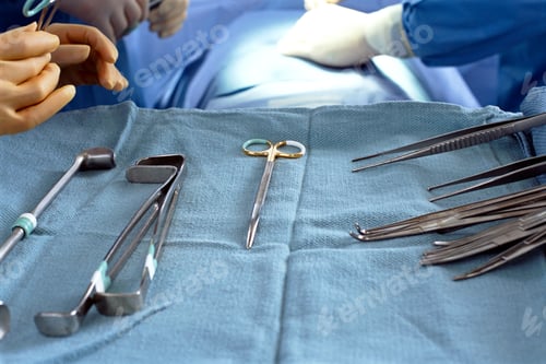 Preview: A Closeup Of Clean Surgical Tools Lying On A Tray With Patient Being Operated By Surgeons In