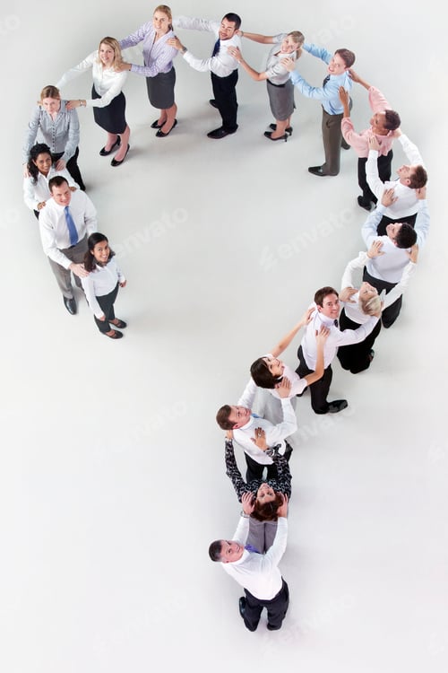 Preview: Vertical Overhead Shot Of Businesspeople Standing In Formation Of A Question Mark With Hands On