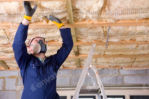 Preview: A Man In Coveralls Wearing Protective Mask Standing On A Ladder And Installing Ceiling Insulation