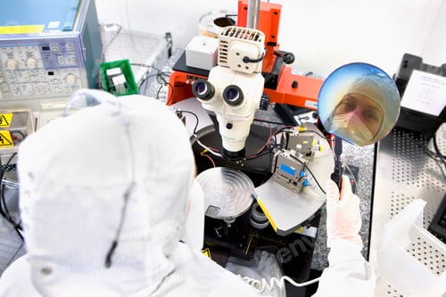 Preview: A High Angle View With Reflection Of The Scientist On A Silicon Wafer Next To The Microscope In A