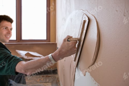 Preview: A Close Up Shot Of A Man Plastering Wall With A Trowel.