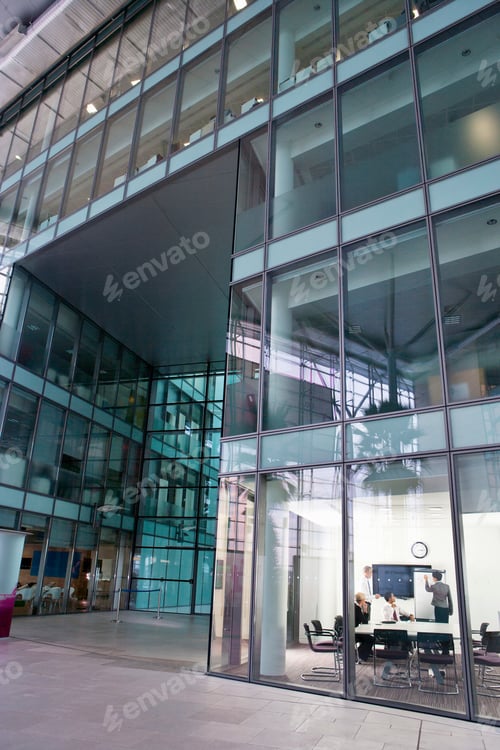 Preview: A Vertical Wide Shot Of People In A Conference Room Through Window Of A High-Rise Building.