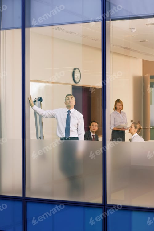 Preview: A View Of Businessman Looking Out Of The Conference Room Through A Glass Window With Co-Workers