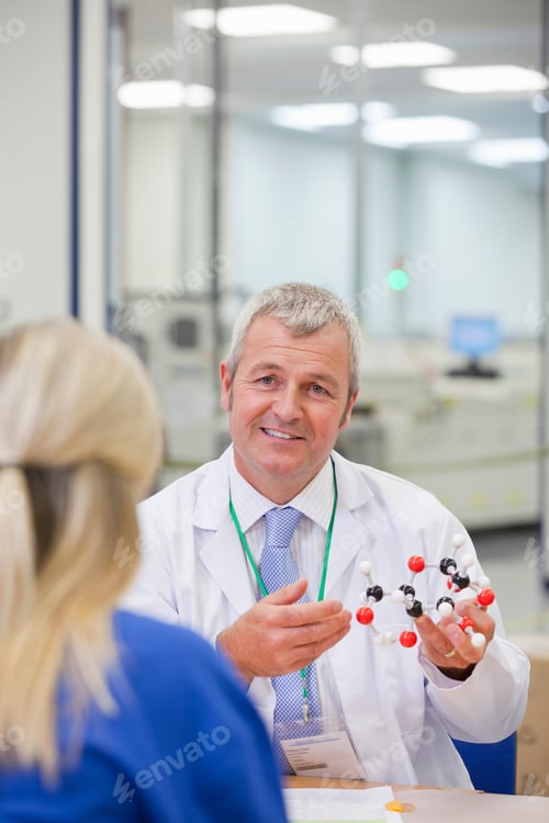 Preview: Vertical Over The Shoulder Shot Of A Manager With A Molecular Structure Talking To A Female Worker