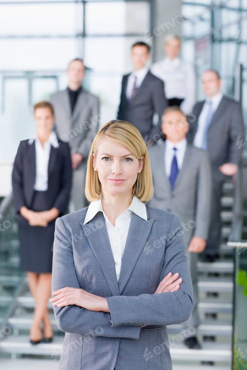 Preview: Portrait Of A Confident Businesswoman Having Her Arms Crossed In A Formal Suit With Colleagues