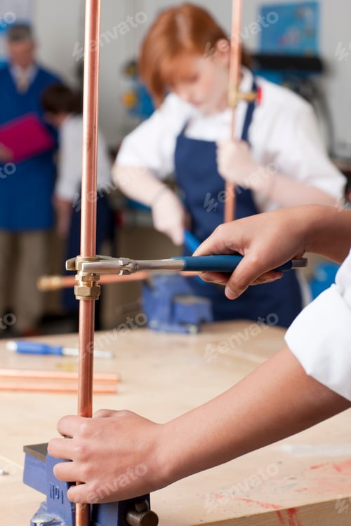 Preview: A Close Up Vertical Shot Of A Student'S Hand Using Wrench To Tighten Valve On A Cooper Plumbing