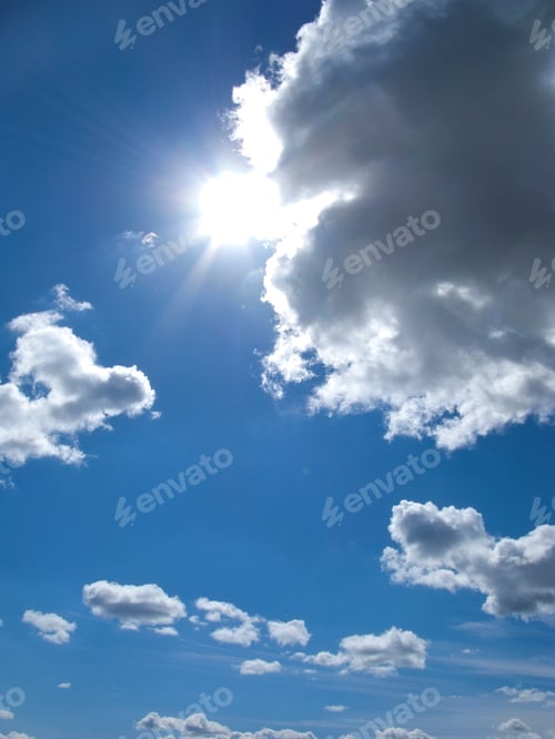 Preview: A Low Angle Vertical Shot A Bright Sun Coming Out From Clouds In A Blue Sky.