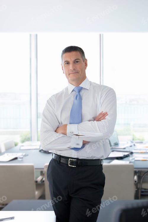 Preview: A Portrait Of A Confident Businessman In Formal Wear Standing Next To A Desk In An Office With His