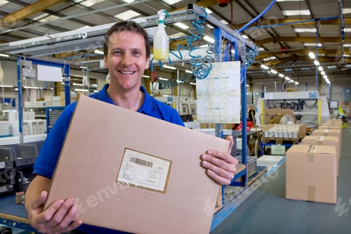 Preview: A Happy Worker Holding And Showing The Final Packaged Box Picked Up From The Assembly Line In A