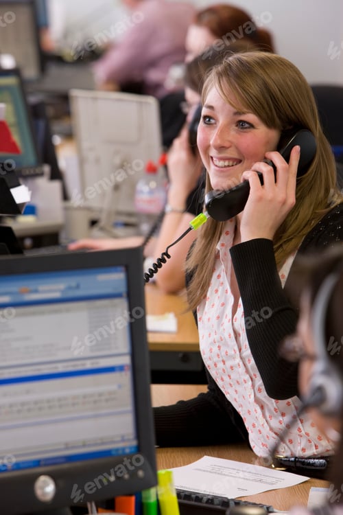 Preview: A Side Profile Portrait Shot Of A Smiling Young Saleswoman Talking On Telephone.