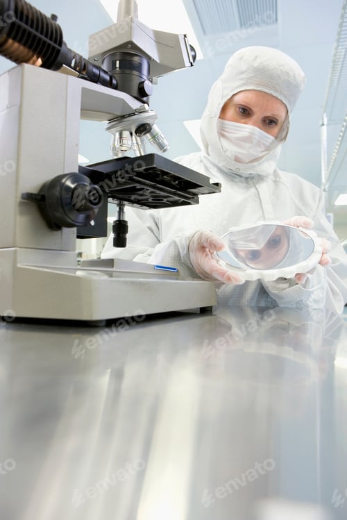 Preview: A Vertical View Of A Scientist In Clean Suit Closely Examining The Silicon Wafer While Standing