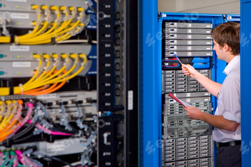 Preview: Medium Wide Shot Of An It Technician Holding Pen And Paper Examining Lan Network In Selective Focus