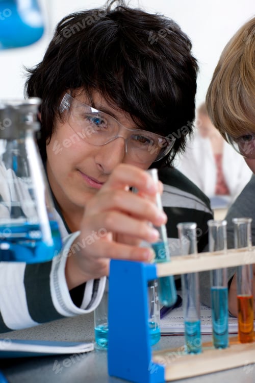 Preview: A Portrait Close Up Shot Of A Young Boy Performing Experiment With Test Tubes In A School Chemistry