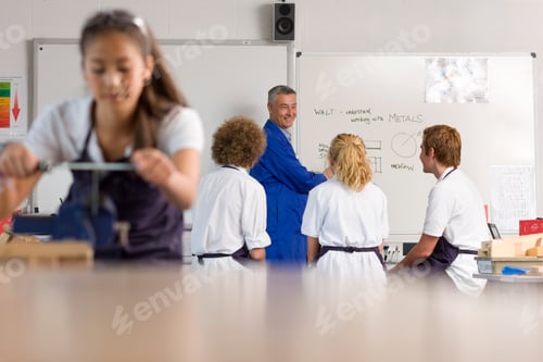 Visualização: Um treinador sorridente em uniforme azul ensinando seus alunos em um quadro branco sob foco seletivo com