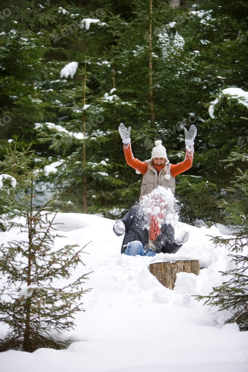 Preview: A Portrait Shot Of A Happy Woman Throwing Snow On Her Husband'S Head In The Woods.