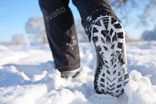 Preview: A Close Up Shot Of A Woman'S Feet Walking Through A Field Of Snow.