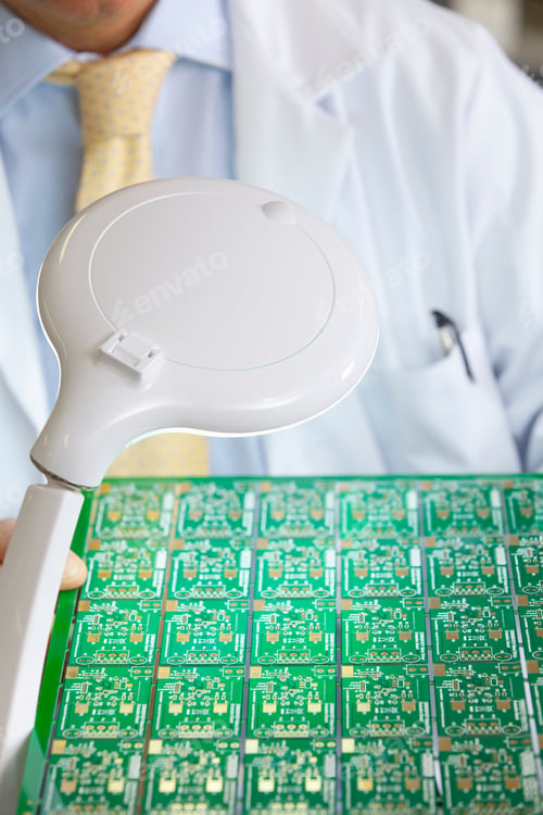 Preview: A Closeup Of A Magnification Lamp Illuminating The Circuit Board Held By An Engineer For Examining