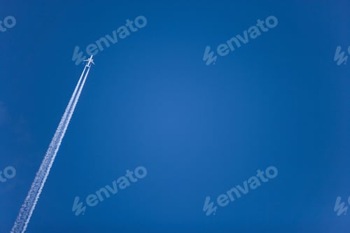 Preview: An Airplane With Leaving A Contrail While Flying In A Clear Blue Sky.