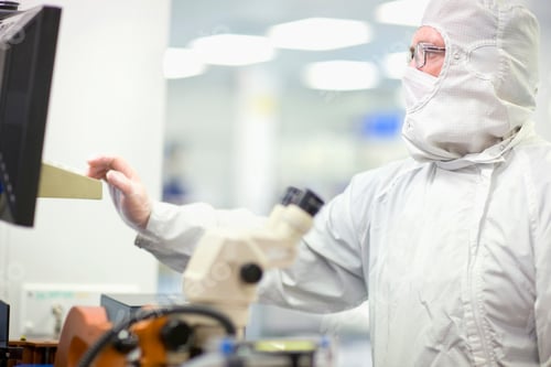 Preview: A Side-View Of A Scientist In Clean Suit And Eyeglasses Working On A Computer In The Silicon Wafer
