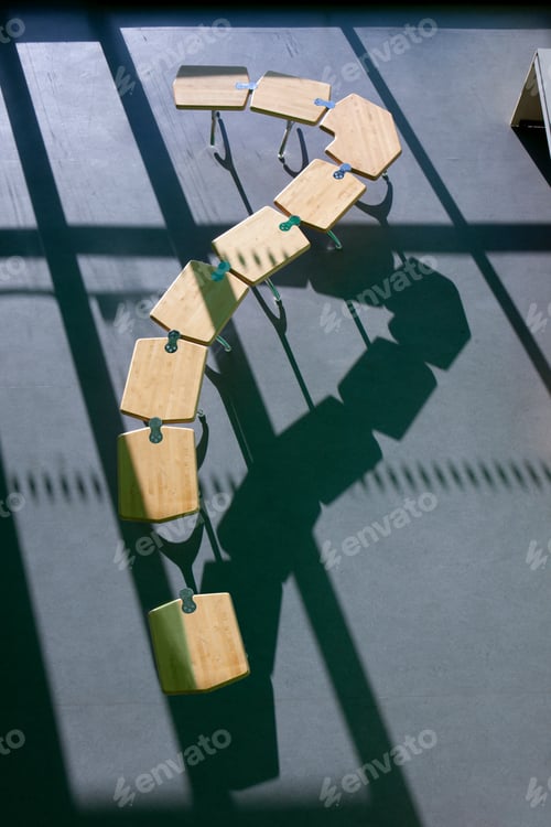 Preview: A High Angle Vertical Shot Of A Row Of School Desks Placed Like A Question Mark Symbol.