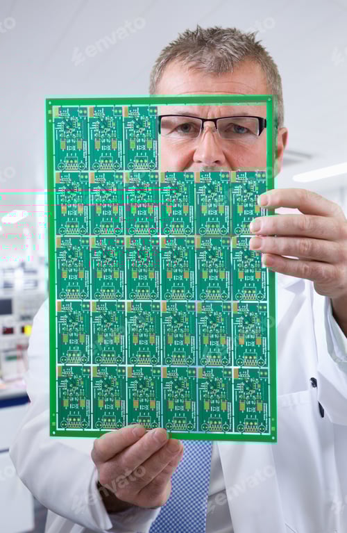 Preview: A Vertical Closeup Of An Engineer In Selective Focus Examining A Printed Circuit Board While