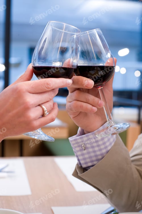Preview: A Portrait Close Up Shot Of A Couple'S Hands Toasting Glasses With Red Wine.